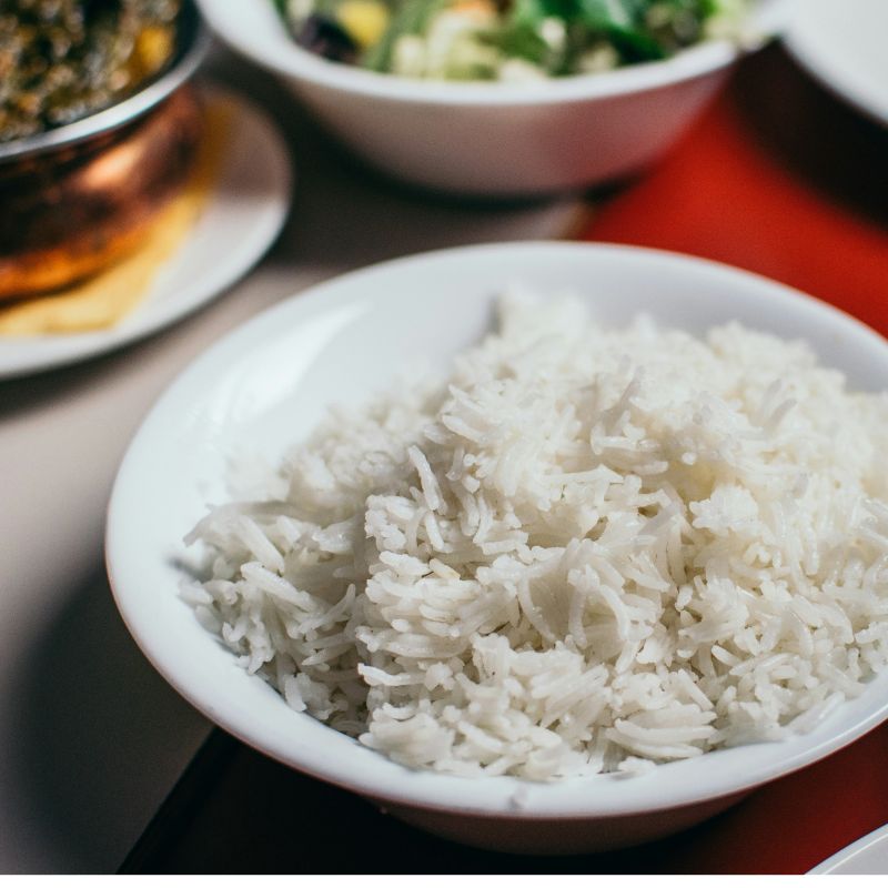 Bol de riz blanc cuit pour prise de masse avec accompagnements curry et salade, parmi les 6 meilleures recettes hypercaloriques