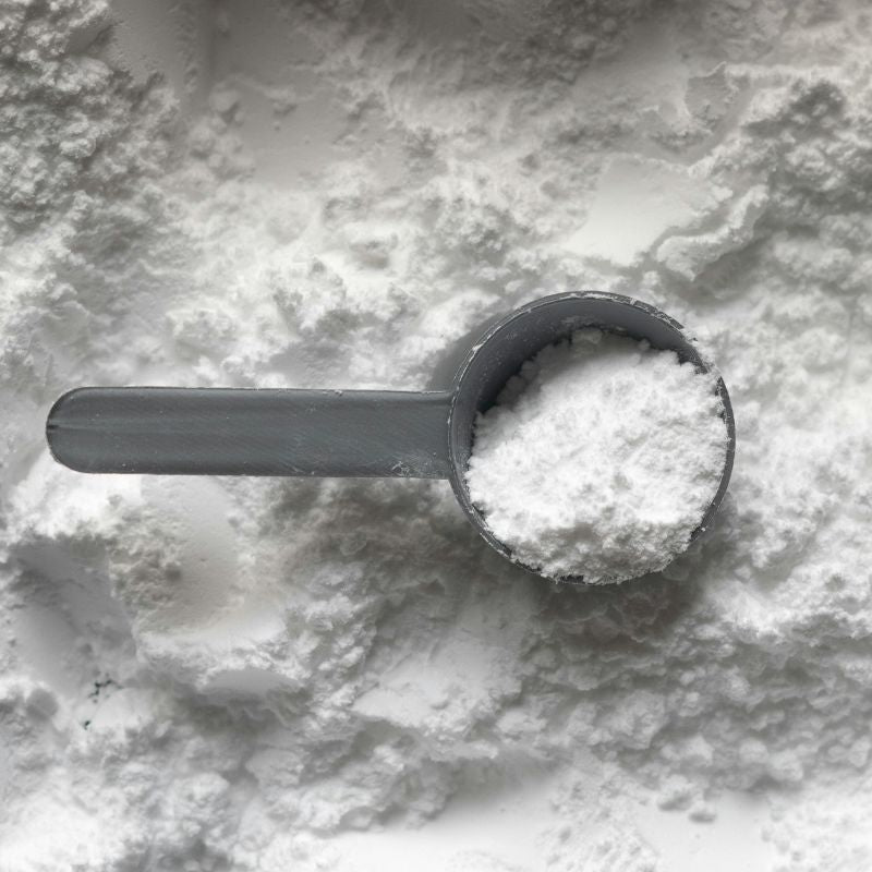 Cuillère mesure gris pleine de poudre de glutamine blanche en vrac, complément alimentaire en musculation avis complet utile ou pas