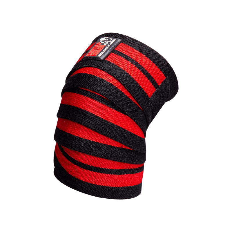 Paire de bandes de genoux Gorilla Wear noires et rouges déroulées pour le soutien lors des squats lourds