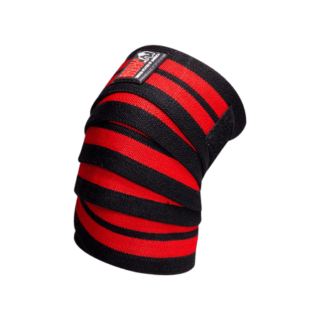 Paire de bandes de genoux Gorilla Wear noires et rouges déroulées pour le soutien lors des squats lourds