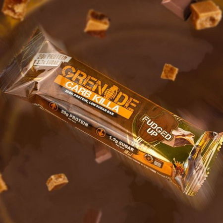 Barre protéinée Grenade Carb Killa Fudged Up 60 g en gros plan sur fond chocolat avec éclats de fudge, apportant 20 g de protéines pour seulement 1,7 g de sucre