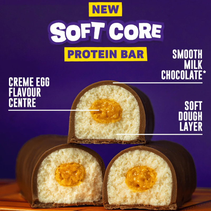 Gros plan d’une barre protéinée Grenade Soft Core goût Creme Egg, enrobée de chocolat au lait avec centre fondant et pâte moelleuse
