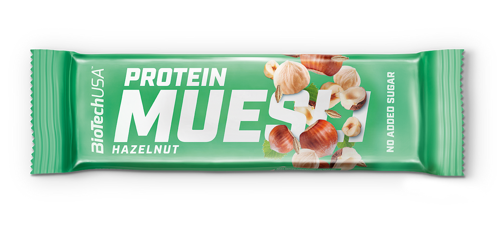 Barre Protein Muesli BiotechUSA saveur noisette dans un emballage vert, illustré de noisettes entières et décortiquées avec indication no added sugar sur le côté