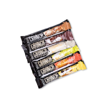 Lot de plusieurs barres protéinées Warrior Crunch alignées en éventail montrant différentes saveurs colorées sur emballages noirs