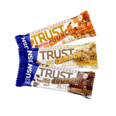 Trois barres USN Trust Crunch alignées présentant les saveurs salted caramel peanut, white choc cookie dough et fudge brownie, chacune avec 20 g de protéines