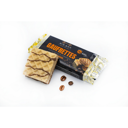 Gaufrette protéinée moka Air Bar sortie du sachet, accompagnée de grains de café entiers devant l’emballage noir et orange