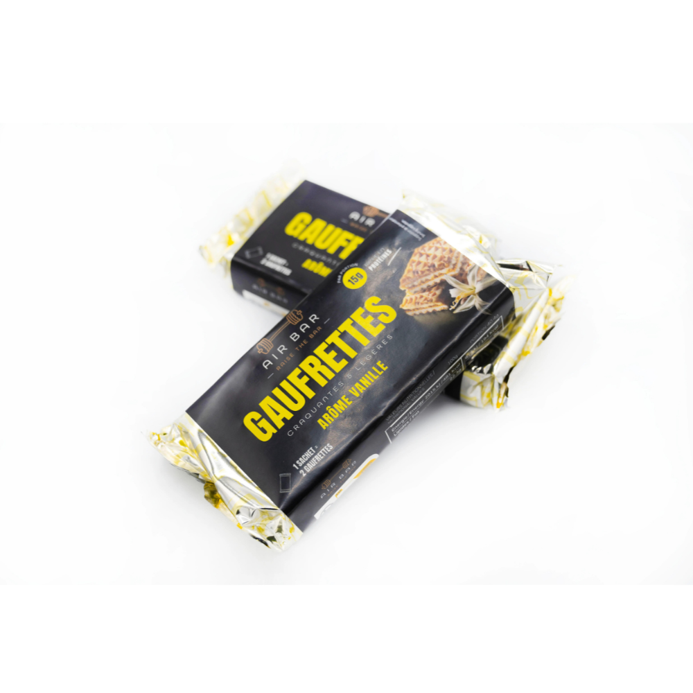 Gaufrette protéinée vanille Air Bar partiellement sortie de l’emballage, montrant plusieurs couches croustillantes striées de chocolat sur fond blanc