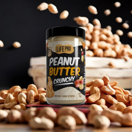 Pot de beurre de cacahuète LifePro Peanut Butter Crunchy 1 kg posé au milieu de cacahuètes entières sur fond sombre pour illustrer une texture croquante riche en fibres
