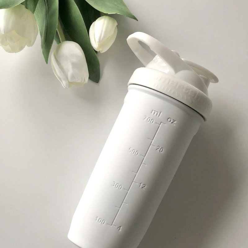 Shaker Smartshake Reforce Steel blanc vu de côté avec graduations en millilitres et décor de fleurs blanches