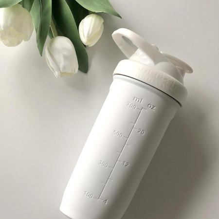 Shaker Smartshake Reforce Steel blanc vu de côté avec graduations en millilitres et décor de fleurs blanches