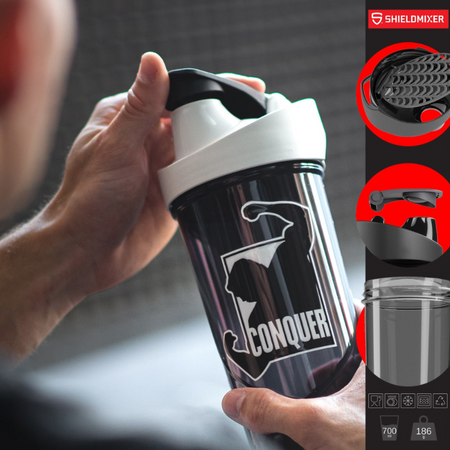 Shaker Shieldmixer Conquer noir 700 ml tenu en main avec couvercle blanc et noir en situation d’entraînement